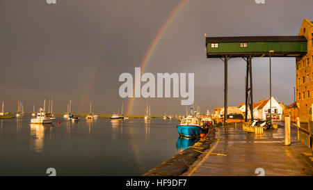 Un arc-en-ciel se forme au-dessus de Wells-next-the-Sea au cours d'une soirée d'orage. Banque D'Images