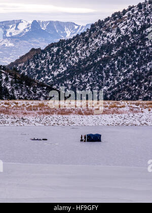 Groupe de pêcheurs de glace sur un lac gelé avec chien, orientation portrait Banque D'Images