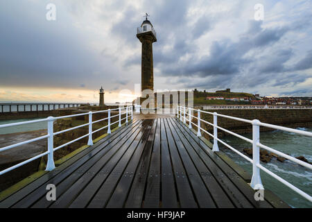 Phare de Whitby et pier au lever du soleil. North Yorkshire, UK Banque D'Images