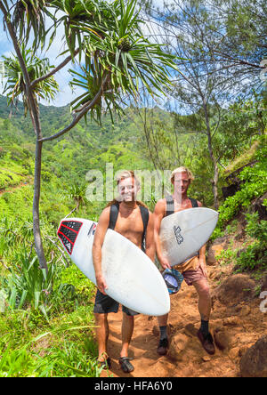 Les randonneurs avec des planches sur le robuste Kalalau Trail sur Kauai sur leur façon de naviguer à risqué Hanakapiai Beach Banque D'Images