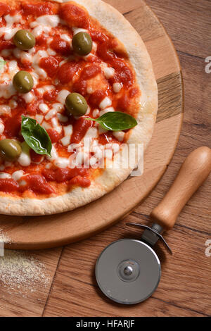 Italian Pizza aux olives vertes sur une planche à découper Banque D'Images