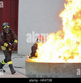 Deux pompiers lors d'un entraînement au large un énorme incendie dans le brasero Banque D'Images