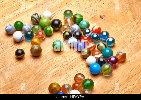 Lot de billes multicolores sur planche de bois. Concept de comité permanent de la foule Banque D'Images