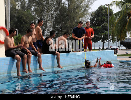 Technicien en électronique de la Garde côtière des États-Unis 3e classe Eric Lang, un nageur-sauveteur de la surface affectée à la légende-class coupe Waesche sécurité nationale USCGC (WMSL 751), et un membre de l'organisme d'application Maritime de la Malaisie 'cinq." L'état de préparation et de formation à la coopération 2012 120616-N-KO052-289 Banque D'Images