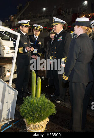 Le capitaine Yasuhiro Sato, commandant de la Force d'autodéfense maritime Japon missiles JS Kirishima (DDG 174), présente un Kadomatsu, un jeton traditionnel japonais de bonne fortune, de la Cmdr. Hans De pour et le Cmdr. Amy Graham, commandant et directeur général de missiles de l'USS Curtis Wilbur (DDG 54), au cours d'un échange de cadeaux de Noël. Curtis Wilbur et Kirishima ont été navires jumeaux depuis 1996 lorsque Curtis Wilbur déplacé à Yokosuka et ont échangé des cadeaux chaque année au cours des 17 dernières années. (U.S. Photo par marine Spécialiste de la communication de masse 3e classe Paul Banque D'Images