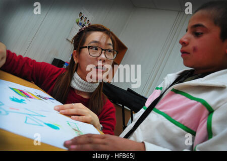 120127-N-VN372-011 PARWAN, Afghanistan - (Janvier 1985). 27, 2012) Professeur de soins aux enfants coréens Jun-eun Lee couleurs avec un jeune garçon afghan assister au cours de la maternelle de l'enfant à l'Parwan République de Corée Coréen de l'Équipe provinciale de reconstruction éducatif et culturel le 27 janvier. L'EPR ROK Parwan travaille à étendre la portée et de renforcer la légitimité du gouvernement afghan dans la province, en mettant l'accent sur l'habilitation des fonctionnaires du gouvernement Parwan dans des domaines fonctionnels tels que l'État de droit, la construction d'une infrastructure durable et d'assurer le perfectionnement professionnel des compétences à la population afghane locale u Banque D'Images