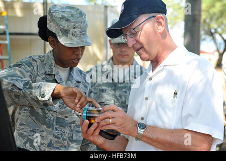 Airman Senior joie Cooper, entomologiste au 647 e Escadron de génie civil, indique Donald R. Schregardus, secrétaire adjoint de la Marine (Environnement), une noix de coco préservé du scarabée rhinocéros (CRB) larve lors de sa visite à Joint Base Harbor-Hickam JBPHH (pearl). Le CRB est un profil élevé et les espèces envahissantes est un ravageur des cocotiers et d'autres espèces de palmiers. Au cours de sa visite, Schregardus ont visité plusieurs sites sur JBPHH d'atténuation CRB, ainsi que des aires d'importance écologique sur Pacific Missile Range Facility, à : Nohili Dunes, Turtle Cove et les nids des oiseaux de Shearwater et sanc Banque D'Images