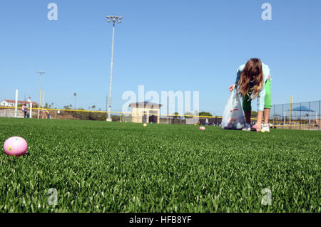 GUANTANAMO BAY, Cuba - la fille d'un militaire rassemble jusqu'oeufs de Pâques au cours d'une chasse aux œufs de Pâques à Cooper, complexe sportif sur le terrain de la station navale des États-Unis à Guantanamo Bay, le 3 avril 2010. La chasse aux œufs de Pâques a été accueilli par le moral, de bien-être et de loisirs de la station navale des États-Unis à Guantanamo Bay et la Force opérationnelle interarmées (FOI) Guantanamo personnel. Guantanamo la foi mène sûr, humain, juridique et transparent le soin et la garde des détenus, y compris ceux qui ont été condamnés par une commission militaire et ceux commandés libéré par un tribunal. La foi mène des activités de collecte, d'analyse et de diffusion pour la protection Banque D'Images