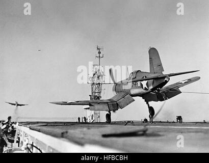 Un F4U-1 Corsair du Fighter Squadron VF-17 atterrit sur le porte-avions USS charger pendant la seconde Guerre mondiale, illustrant les opérations de l'aviation navale. Banque D'Images
