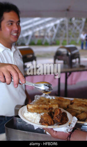 GUANTANAMO BAY, Cuba - membre de la célébration de la Journée de l'indépendance philippine Comité sert de nourriture pour les usagers des événements, le 14 juin 2008. La cuisine philippine a été un grand moment de Saturday's 110e jour de l'indépendance des Philippines célébration ici. La foi mène des opérations d'interrogatoire pour recueillir du renseignement stratégique à l'appui de la guerre mondiale contre le terrorisme et prend en charge l'application de la loi et les enquêtes sur les crimes de guerre. Guantanamo la foi s'est engagé à assurer la sécurité et la sécurité de l'American service members et les civils qui travaillent à l'intérieur de sa détention. (Foi Guantanamo photo par le Sgt Major de l'armée. Emily Banque D'Images