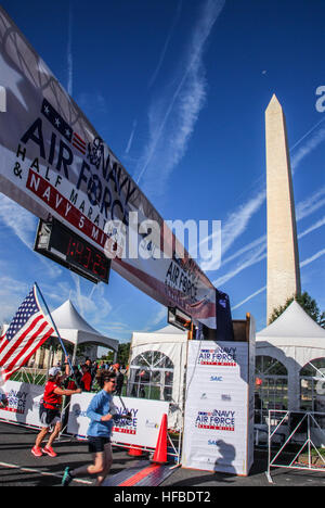 Julie Fox, originaire de Gilford, Ind., mais vivant actuellement à Mechanicsville, Md., traverse la ligne d'arrivée en portant un drapeau américain à l'Navy-Air 2014 Force 5-Miler/Half-Marathon, qui a commencé au pied du Monument de Washington dans la capitale du pays. Le drapeau a été utilisé pour la première fois sur le cercueil du père de Fox, un ancien combattant de la Seconde Guerre mondiale, qui est décédé en novembre 2010, et délivré par l'armée pour la mère de Fox. Juste avant la course, le mari de Fox, ancien capitaine de l'Armée de l'air Le Sgt. Massie, Fox a pris des dispositions pour obtenir l'indicateur d'un membre de la famille, alors surpris sa femme avec le drapeau. "Je Banque D'Images