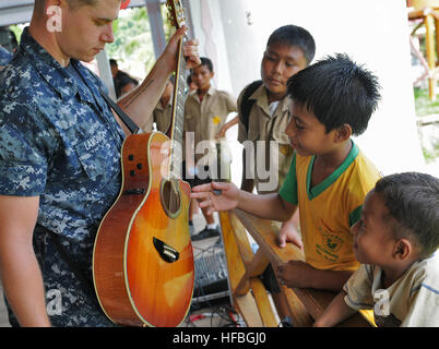 120609-N-GI544-167 TALAUD, l'Indonésie, l'Indonésie (9 juin 2012) Musicien 3ème classe Steve Lamonica vous permet d'enfants indonésiens locaux strum sa guitare lors d'un partenariat du Pacifique 2012 Projet de service communautaire. Partenariat du Pacifique est un rapport annuel de la flotte américaine du Pacifique et humanitaire de la mission d'assistance civique qui en est maintenant à sa septième année qui regroupe le personnel militaire américain, l'hôte et les pays partenaires, les organisations non gouvernementales et les organismes internationaux pour renforcer les relations et développer des capacités de réaction aux catastrophes dans la région Asie-Pacifique. (U.S. Photo de la marine en masse Communicat Banque D'Images