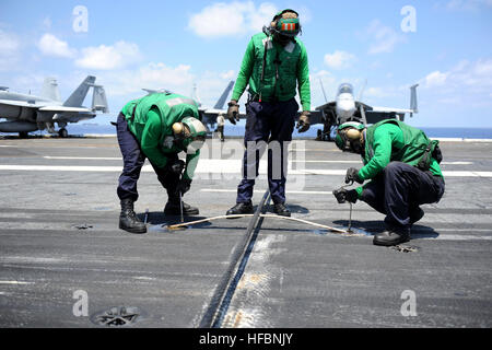 110711-N-DE843-073 OCÉAN ATLANTIQUE (11 juillet 2011) l'Aviation Boatswain's mates remplacer un support de câble de vitesse pendant les opérations de vol à bord du porte-avions USS Dwight D. Eisenhower (CVN 69). Dwight D. Eisenhower est en cours la réalisation des qualifications de l'opérateur en préparation de son prochain déploiement. (U.S. Photo par marine Spécialiste de la communication de masse 3 classe Bradley Evans/libérés) - Imagerie de la marine américaine - Les Marins remplacer un support de câble arrêt à bord de l'USS Dwight D. Eisenhower. Banque D'Images