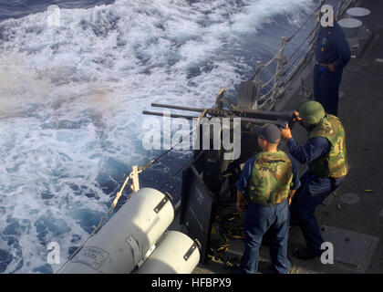 110220-N-5838W-002 MER ROUGE (fév. 20, 2011) Gunners Mate 2e classe Edward Shoman, gauche, supervise technicien électronique 2e classe Yusuf Smith comme il tire de calibre 50 une machine gun à bord du destroyer lance-missiles USS Mason (DDG 87) Master Chief Raymond Kemp, droite, observe les deux marins. Mason est déployée dans le cadre de l'entreprise, Groupe aéronaval d'appuyer les opérations de sécurité maritime et les efforts de coopération en matière de sécurité dans le théâtre aux États-Unis 5e domaines de responsabilité. (U.S. Photo par marine Spécialiste de la communication de masse 3 Classe Jeffry A. Willadsen/libérés) - La Marine américaine officielle Banque D'Images
