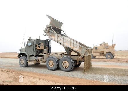 La province d'Helmand, en Afghanistan (19 avril 2012) un camion-benne exploité par un affecté à Seabee Construction Mobile Marine Bataillon (NMCB) décharges 11 gravier pour un projet de construction de route dans le sud de la Province d'Helmand, en Afghanistan, qu'un autre véhicule fournit la sécurité. NMCB-11 est homeported à Gulfport, Mississippi, et est déployée en Afghanistan pour mener, mobilité, survivabilité générale des opérations d'ingénierie, les opérations défensives, le partenariat de l'Armée nationale afghane et le détachement d'unités dans la zone d'opérations conjointes et combinées, en Afghanistan. (U.S. Photo par marine Spécialiste de la communication de masse 1re classe Jona Banque D'Images