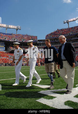 100906-N-3857R-012 BALTIMORE (sept. 6, 2010) Chef de l'état-major des adm. Mike Mullen, gauche, Vice-Adm. Michael Miller, directeur de l'académie navale des États-Unis, le lieutenant Dan Cnossen, un Navy SEAL vétéran et ancien de l'académie navale des États-Unis, et Maryland Sen. Benjamin Cardin à pied au centre du champ de participer à la cérémonie de tirage au sort au cours de l'académie navale des États-Unis de football universitaire du premier match de la saison 2010. La perte de la marine à l'Université du Maryland, 17-14. (U.S. Photo par marine Spécialiste de la communication de masse 1re classe Tchad Runge/libérés) - Imagerie de la marine américaine - Sen. Benjamin Banque D'Images