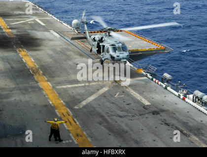 Un MH-60S Sea Hawk affectés à l'Escadron d'hélicoptères de combat de la mer (HSC) 21 se prépare à atterrir sur le pont d'envol du navire d'assaut amphibie USS Peleliu (LHA 5). Peleliu est le premier navire du groupe amphibie de Peleliu et est le dernier déploiement prévu à la 7ème Flotte américaine zone de responsabilité avant la mise hors service au début de l'année prochaine. (U.S. Photo par marine Spécialiste de la communication de masse 3 classe Dustin Knight/relâché), opérations de vol 140922-N-HU377-034 Banque D'Images