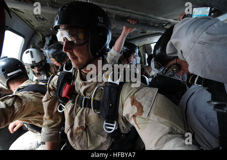 Les marins affectés à l'unité mobile de destruction des engins explosifs 1 et 3 de l'Unité des opérations spéciales de la marine se tiennent prêts à une altitude de 10 000 pieds à bord d'un SH-60 Sea Hawk avant un saut en chute libre exercice d'entraînement. EODMU-1 et NSWU-3 mènent des opérations conjointes de formation à Manama, Bahreïn, pour accroître la cohérence entre les deux unités de guerre spécial. Exercice d'entraînement de saut en chute libre 275349 Banque D'Images