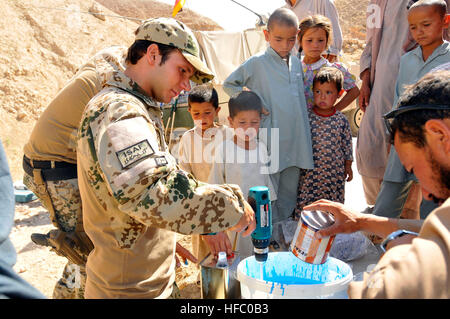 Les résidents Ghandaki regardez comme un soldat allemand mélange une peinture époxy spécial pour l'intérieur de la cuve de stockage d'eau du village. La Force internationale d'assistance, le Commandement régional Nord, Bureau de Coopération Militaire Civil construit les 60 000 gallons (227 000 litres) de stockage de l'eau contenant à la base de leur village à 40 kilomètres à l'extérieur du camp Marmal, près de la ville de Mazar-e Sharif pour soutenir les 500 personnes qui y vivent. Récipient de l'eau village Ghandaki 110731-N-LU859-167 Banque D'Images