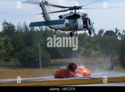 SANTA RITA, Guam (fév. 20, 2015) - UN MH-60S Knighthawk avec les "Chevaliers" de l'île de la mer de l'Escadron d'hélicoptères de combat (HSC)-25, plane au-dessus de l'eau un 'pumpkin' pour recueillir l'eau d'un seau "Bambi" de mener une "Bambi Bucket incendie aérienne' mission de formation, dans le cadre de la lutte contre les incendies de forêt les missions de formation réalisées le 20 février au Naval Magazine, commande de munitions navales, Naval Base Guam (NBG). (U.S. Photo de Jeff marine Landis/libérés) HSC-25 effectue des formations de forêt 150220-N-OG363-024 Banque D'Images