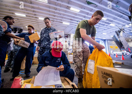 Le courrier est trié dans la baie du hangar de l'USS Bonhomme Richard (LHD 6) après livraison pendant le réapprovisionnement en cours. Le navire, navire amiral du Bonhomme Richard Amphibious Ready Group avec la 31e Marine Expeditionary Unit, mène des opérations de routine dans la zone de responsabilité de la 7e flotte américaine. Banque D'Images