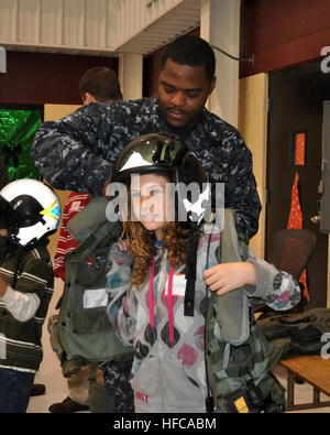 Maître de 3e classe Donte Nickerson, arrimeur, aide une petite fille essayer sur une veste de survie lors d'une visite avec l'escadron de l'air Marine 57 dans le cadre de la Make-A-Wish Foundation's visite de la Naval Air Station North Island. (Photo par : Maître de 1re classe Shawn D. Torgerson) Make a Wish Foundation Visitez 231981 Banque D'Images