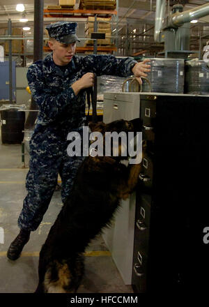 Seaman Brandon Taylor, un gestionnaire certifié affecté au quartier de la marine militaire de Washington Programme chien de travail, effectue une évolution explosive à l'intérieur de la compétence d'un entrepôt public works at Joint Base Anacostia-Bolling. Le programme offre des MWD NDW la lutte contre le terrorisme et la protection de la force d'assistance à la sécurité de la base. Chien de travail militaire 363056 Banque D'Images