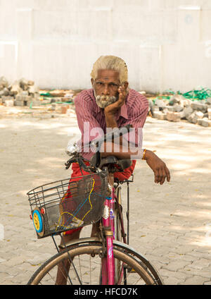 L'homme indien vieux avec des cheveux gris et un ours gris assis sur son vélo Banque D'Images