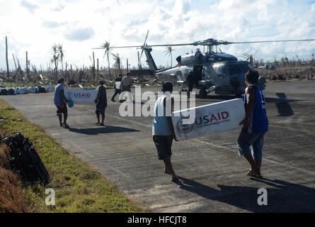 131117-N-AU127-001 GUIUAN, Eastern Samar Province, République des Philippines (nov. 17, 2013) marins affectés à la George Washington Group (GWCSG) et les citoyens des Philippines travailler ensemble pour charger un MH-60R Seahawk hélicoptère à partir de l'hélicoptère "Saberhawks" de grève Maritime Squadron (HSM) 77 à l'appui de l'opération Damayan. Le Groupe George Washington appuie la Force opérationnelle 505 qui est d'aider le gouvernement des Philippines en cours d'efforts de secours à la suite de la super typhon Haiyan/Yolanda. (U.S. Photo par marine Spécialiste de la communication de masse 2e Banque D'Images