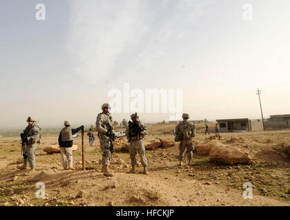 Des soldats américains, affecté à la 3e Bataillon, 8e régiment de cavalerie lourde, 3e Brigade Combat Team, 1re Division de cavalerie, et les soldats de la 3e équipe de transition de la Police fédérale, tirer la sécurité pendant que les membres de leur équipe en collaboration avec les officiers de la Police fédérale au cours d'une mission de l'encerclement et de recherche, à une maison de ferme à la périphérie de Mosul, Iraq, le 5 novembre 2009. La zone était soupçonné d'être utilisé en tant que véhicule la charge explosif de l'usine. L'opération Iraqi Freedom 221001 Banque D'Images