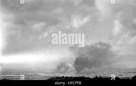 Vue panoramique de Pearl Harbor, pendant le raid japonais, avec les explosions d'obus au-dessus. Le sud-ouest de la photographie a l'air les collines derrière le port. Grande colonne de fumée dans le centre inférieur droit de la combustion est USS Arizona (BB-39). Fumer un peu plus loin à gauche est de la Shaw destroyers (DD-373), Cassin (DD-372) et Downes (DD-375), dans les cales sèches Pearl Harbor Navy Yard. Photographie de la Marine américaine officielle, aujourd'hui dans les collections des Archives nationales. Attaque de Pearl Harbor View Large Banque D'Images