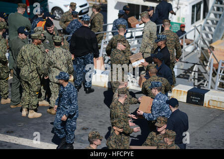 Les Marines américains affectés à la 22e unité expéditionnaire maritime et les marins affectés à la station de transport amphibie USS Mesa Verde (LPD 19) charge boîtes de nourriture et de fournitures sur le bateau tandis qu'il ravitaille à la station navale de Rota, Espagne, le 24 février 2014. Les marins et soldats étaient des efforts de sécurité et de fournir une capacité d'intervention de crise aux États-Unis la 5ème et la 6ème flotte domaines de responsabilité. (U.S. Photo par marine Spécialiste de la communication de masse 2e classe M. Shannon Smith/PHIBLEX) Parution 140224-N-BD629-286 Banque D'Images