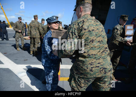 Les Marines américains affectés à la 22e unité expéditionnaire maritime et les marins affectés à la station de transport amphibie USS Mesa Verde (LPD 19) charge boîtes de nourriture et de fournitures sur le bateau tandis qu'il ravitaille à la station navale de Rota, Espagne, le 24 février 2014. Les marins et soldats étaient des efforts de sécurité et de fournir une capacité d'intervention de crise aux États-Unis la 5ème et la 6ème flotte domaines de responsabilité. (U.S. Photo par marine Spécialiste de la communication de masse 2e classe M. Shannon Smith/PHIBLEX) Parution 140224-N-BD629-332 Banque D'Images