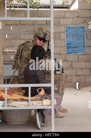 L'Armée américaine William Russell, une force de sécurité de l'équipe provinciale de reconstruction (EPR) Farah, siège avec deux jeunes garçons afghans lors d'un chef de l'engagement à la prison de la ville de Farah, le 6 décembre. PRT Farah a pour mission de former, de conseiller et d'aider les dirigeants du gouvernement afghan à l'échelle municipale, du district et de la province dans la province de Farah, l'Afghanistan. Leur équipe militaire civil est constitué de membres de la Marine américaine, l'armée américaine, le Département d'État des États-Unis et de l'Agence pour le développement international (USAID). (U.S. Photo par Marine Josh HMC Ives/libérés) PRT Farah effectue leader clé s'engager Banque D'Images