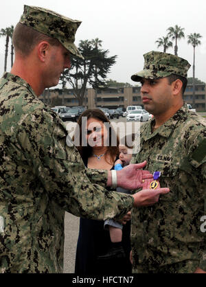 130315-N-SD PORT HUENEME120-002, Californie (15 mars 2013) 3e classe constructeur Brandon Bernal, 26 ans, a remporté la médaille Coeur violet par le Capitaine Dean Tufts, commandant du groupe de construction navale (NCG) 1 comme l'épouse de Bernal, Adrienne, et fils Branden se tiennent près de lui. Bernal, affectés à la construction navale (bataillon Mobile NMCB) 5, a reçu la Purple Heart pour des blessures subies lorsque son véhicule a été touché par un engin explosif improvisé dans la province de Helmand, Afghanistan, le 12 août 2010. U.S. Navy photo by Mass Communication Specialist 1re classe John P. Curtis. (Libéré) Purple Banque D'Images