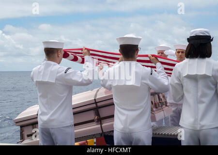 Les marins américains commettre un cercueil dans la mer Juin 22, 2014, au cours d'une cérémonie d'enterrement en mer pour 22 anciens combattants et membres de leur famille à bord du navire d'assaut amphibie USS Peleliu (LHA 5) dans l'océan Pacifique. Le Peleliu était de participer à l'exercice 2014, un américaines du Pacifique a organisé l'exercice maritime multinational biennal destiné à encourager et soutenir la coopération internationale sur la sécurité des océans du monde. (U.S. Photo par marine Spécialiste de la communication de masse Seaman Amanda Chavez/libérés) de l'exercice RIMPAC 2014 140622-N-LR795-074 Banque D'Images