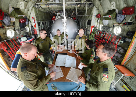 L'équipage d'un Hercules C-130, attribué à 435 e Escadron de transport et sauvetage, examine le plan de vol avant une mission de ravitaillement au cours de Rim of the Pacific (RIMPAC) 2014. Vingt-deux nations, 49 navires, 6 sous-marins, plus de 200 avions et 25 000 personnes participent à l'EXERCICE RIMPAC du 26 juin au 1 août dans et autour des îles Hawaï et la Californie du Sud. Le plus grand exercice maritime international RIMPAC, offre une formation unique qui aide les participants à favoriser et soutenir les relations de coopération qui sont essentielles pour assurer la sécurité Banque D'Images