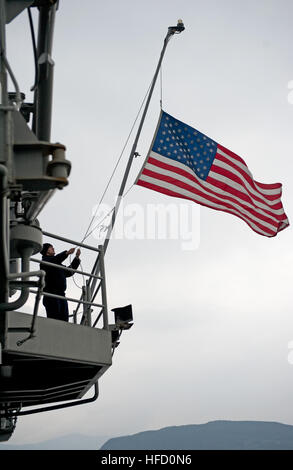 SASEBO, Japon (Janv. 24, 2013) 2ème classe Controlman Incendie Nikolaus Martinez, affecté à l'assaut amphibie USS Bonhomme Richard (DG 6), s'abaisse le drapeau national à bord du navire pendant son déploiement prévu. Le Bonhomme Richard Groupe amphibie est en déploiement dans la zone d'opérations de la 7e Flotte et prendront part à la formation d'intégration amphibie (ACI), et l'exercice de certification (CERTEX) et participera à la multi-nationale annuelle d'entraînement interarmées Gold Cobra. (U.S. Photo par marine Spécialiste de la communication de masse de 3e classe Michael Achterling/Relea Banque D'Images