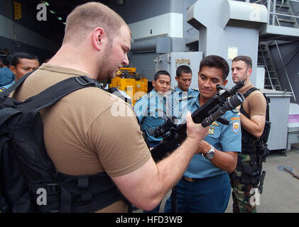 Le lieutenant J.G. Frinell Windsor explique les armes qu'il utilise dans le cadre d'une visite, un conseil, une équipe de recherche, et de la saisie à l'Indonésien les officiers de marine à bord du navire de débarquement quai amphibie USS Harpers Ferry. La démonstration faisait partie d'un exercice bilatéral impliquant des Harpers Ferry, la 31e unité expéditionnaire de Marines et forces armées indonésiennes. Les membres du Service en Indonésie 99678 Banque D'Images