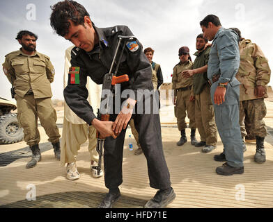 Des membres de la police locale afghane distribuent des fusils AK-47 aux recrues lors d’un cours de tir à sec dans le district de Nawbahar, province de Zabul, Afghanistan, le 24 mars, dans le cadre d’un cours de trois semaines pour enseigner les compétences de base en matière de police, de manipulation des armes et de sécurité nécessaires pour protéger les civils. Banque D'Images