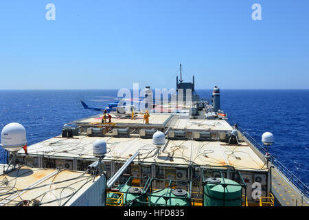 Les membres de l'équipage à décharger des marchandises d'un hélicoptère à bord du porte-conteneurs MV Cape Ray (T-AKR 9679) dans la mer Méditerranée le 4 août 2014. Le gouvernement des États-Unis à 100 Cape Ray a été modifié et déployés à l'est de la Mer Méditerranée pour disposer d'agents chimiques syriennes conformément au cadre convenu de la Syrie à la fin de 2013. (U.S. Photo par marine Spécialiste de la communication de masse Seaman Desmond Parcs/libérés) agents chimiques syriennes destruction 140804-N-XB010-008 Banque D'Images