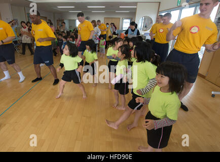 140225-N-IC565-528 Okinawa, Japon (fév. 25, 2014) marins affectés à la station de transport amphibie USS Denver LPD (9) enseigner aux élèves de l'école maternelle Kanasa une danse. Denver est attribué à l'Bonhomme Richard Groupe amphibie et est en train de mener des opérations dans la 7e Flotte des États-Unis zone de responsabilité. (U.S. Photo par marine Spécialiste de la communication de masse 3 classe Bradley J. Gee/libéré) une danse 140225-N-IC565-528 Banque D'Images