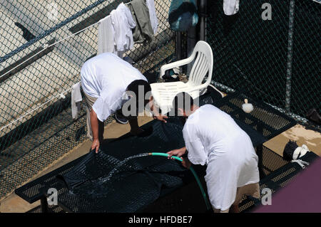 Deux détenus se laver un tapis dans la zone de loisirs de plein air du Camp 6 au groupe de travail conjoint Guantanamo, 18 mars. JTF Guantanamo fournit sûr, humain, juridique et transparent le soin et la garde des détenus, y compris ceux qui ont été condamnés par une commission militaire et ceux commandés libéré par un tribunal. La foi mène des activités de collecte, d'analyse et de diffusion pour la protection des détenus et du personnel travaillant dans la foi et à l'appui des installations de Guantanamo de la guerre contre le terrorisme. Guantanamo la foi apporte un soutien à l'Office de Tourisme de Commissions militaires, à la loi et à des enquêtes pour crimes de guerre Banque D'Images