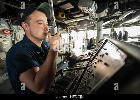 Maître de Manœuvre de la marine américaine de la classe de 3ème port Joshua transmet les informations à la tourelle en position debout du timonier à bord du watch destroyer lance-missiles USS Donald Cook (DDG 75) Le 31 mars 2014, dans la mer Méditerranée. Le Donald Cook était prévue sur une patrouille dans la sixième flotte américaine zone de responsabilité à l'appui de l'approche adaptative progressive des États-Unis et l'OTAN de défense antimissile. (U.S. Photo par marine Spécialiste de la communication de masse Seaman Edward Guttierrez III/libérés) Maître de Manœuvre de la marine américaine de la classe de 3ème port Joshua transmet les informations à l'agent de tourelle en position debout hel Banque D'Images