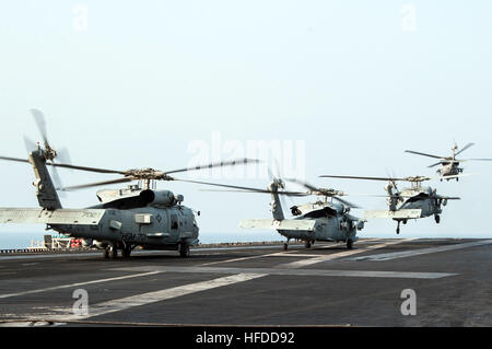 La Marine américaine hélicoptères MH-60S Seahawk affectés à l'Escadron d'hélicoptères de combat de la mer (HSC) et 9 hélicoptères MH-60R Seahawk hélicoptère affecté à l'Escadron grève maritime (HSM) 70 décoller de l'envol du porte-avions USS George H. W. Bush (CVN 77) dans le golfe Persique, le 18 octobre 2014, alors que le navire prend en charge inhérentes résoudre. Le président Barack Obama a autorisé l'acheminement de l'aide humanitaire à l'Iraq, ainsi que des frappes aériennes ciblées pour protéger le personnel américain de la part des extrémistes connus sous le nom de l'État islamique en Irak et au Levant. Le Commandement central américain dirigé les opérations. (U.S. Photo par Marine C Masse Banque D'Images