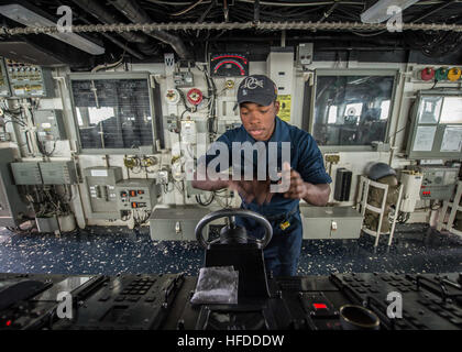 Matelot de la Marine américaine murs Maurice dirige le navire alors qu'il se trouvait à bord du timonier watch destroyer lance-missiles USS Donald Cook (DDG 75) Le 31 mars 2014, dans la mer Méditerranée. Le Donald Cook était prévue sur une patrouille dans la sixième flotte américaine zone de responsabilité à l'appui de l'approche adaptative progressive des États-Unis et l'OTAN de défense antimissile. (U.S. Photo par marine Spécialiste de la communication de masse Seaman Edward Guttierrez III/libérés) U.S. Navy Matelot Maurice murs steers le navire alors qu'il se trouvait à bord du timonier watch destroyer lance-missiles USS Donald Cook (DDG 75) Le 31 mars 2014, Banque D'Images