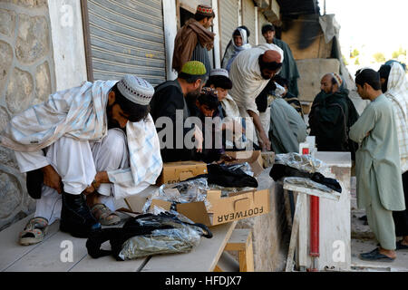 La police locale afghane (ALP) candidats essayer sur leurs nouvelles bottes avant leur cérémonie de remise de diplômes à Arghandab district, province de Kandahar, en Afghanistan, le 3 novembre. ALP candidats sont soumis à trois semaines de cours qui couvre l'adresse au tir de base, les patrouilles, dispositif explosif de reconnaissance et les techniques de sécurité. Compléter les efforts de contre-insurrection de l'ALP, en aidant les zones rurales avec peu de présence des forces de sécurité nationale afghanes, afin de permettre aux conditions de l'amélioration de la sécurité, de la gouvernance et du développement. (U.S. Photo par marine Spécialiste de la communication de masse 2e classe Ernesto Hernan Banque D'Images