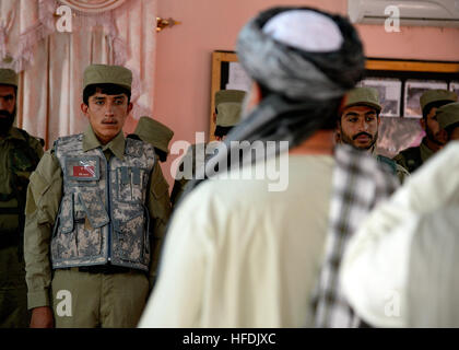 La police locale afghane (ALP) candidats en formation au cours de la Gouverneure du district Shah Mohammad discours lors de leur cérémonie de remise de diplômes à Arghandab district, province de Kandahar, en Afghanistan, le 3 novembre. ALP candidats sont soumis à trois semaines de cours qui couvre l'adresse au tir de base, les patrouilles, dispositif explosif de reconnaissance et les techniques de sécurité. Compléter les efforts de contre-insurrection de l'ALP, en aidant les zones rurales avec peu de présence des forces de sécurité nationale afghanes, afin d'eanable conditions de l'amélioration de la sécurité, de la gouvernance et du développement. (U.S. Photo de la marine en masse Banque D'Images