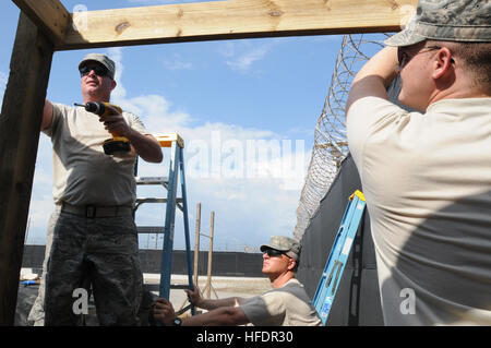 GUANTANAMO BAY, Cuba - Le s.. Jim Charles (à gauche) examine une vis il a fixée dans un chevron tandis que l'Aviateur Senior Matthew Frost prend en charge le chevron dans le cadre de la construction d'un auvent attenant à la cabane de garde à l'entrée de l'expéditionnaire complexe juridique près du camp de la Justice, le 8 février. Charles et le gel sont attachés à la base de la Force de l'ingénieur d'urgence 138e Escadre de chasse, New York Air National Guard ; le 138e prend en charge la Force expéditionnaire de Guantanamo en maintenant le complexe Juridique et justice Camp installations et l'infrastructure. La foi humaine, assure la sécurité de Guantanamo Banque D'Images