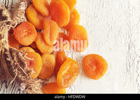 Abricots secs sur fond blanc en bois rustique. Top View with copy space Banque D'Images